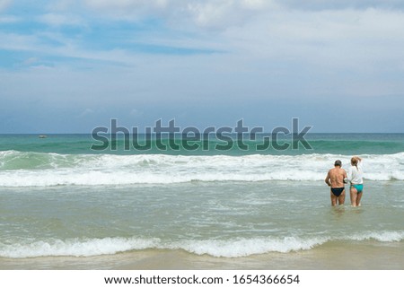 Lover tourist to wear swimming costume or bikini to playing on the beach with wave on holiday,Phuket,Thailand.