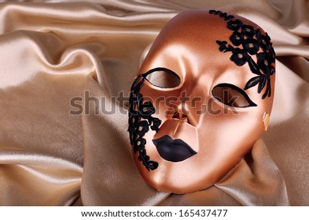 Mask on golden fabric background