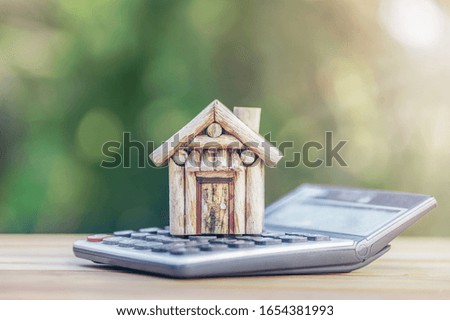 House is placed on the calculator. Imagine calculating to buy a home. planning savings money of coins to buy a home concept for property, mortgage and real estate investment.to buy a house.