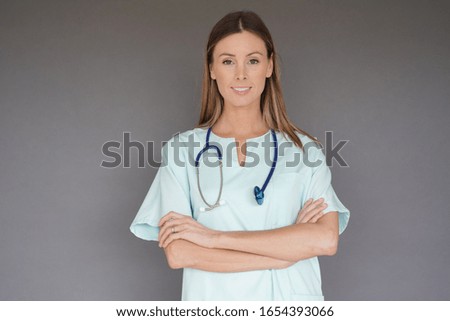 Portrait of nurse standing on grey background, isolated