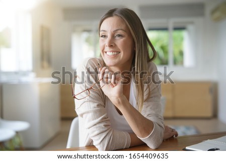 Cheerful woman working from home Royalty-Free Stock Photo #1654409635