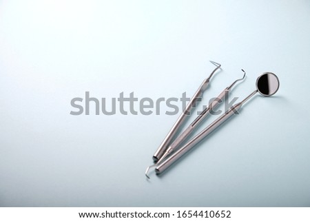 Metal dental tools on a blue background