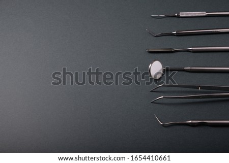 Metal dental tools on a dark background