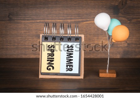 Spring and Summer. Season, holidays, work and vacation concept. Notebook and colorful balloons on the wooden background