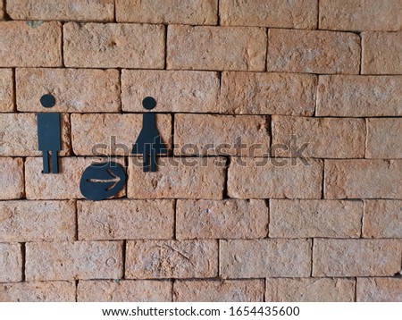 restroom or toilet signs with female and male symbol on old brick background