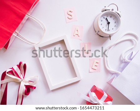 fiat lay of shopping sale concept, bags, picture frame, clock, gift box on white background with copy space.