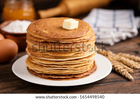 Stack of blini, Russian thin pancakes or crepes with butter on old rustic wooden table. Maslenitsa, Shrove Tuesday concept Royalty-Free Stock Photo #1654498540