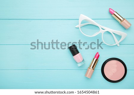 Makeup set on blue wooden background with copy space, top view. Cosmetics