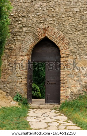 Details and architectural decorations of ancient buildings, stone walls and doors, arches and doorways. On the streets in Georgia, public places. Texture background for design.