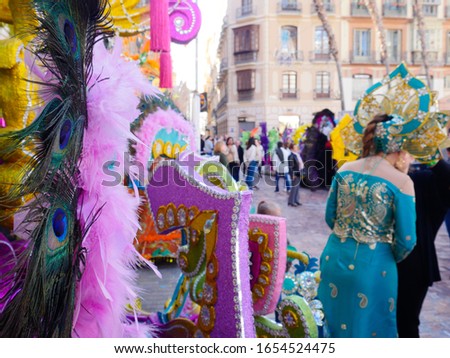 Colorful samba dancers in costumes with sequins and glitter at a daytime Carnival street party.