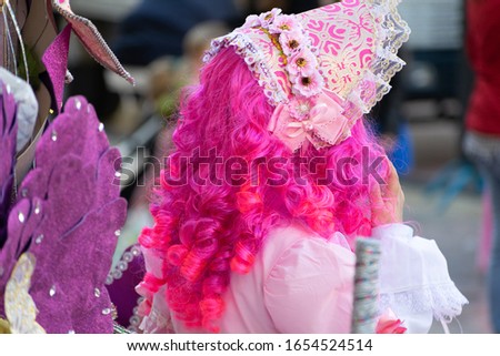 Young girl wearing a pink colorful costume at a street carnival party