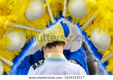 Young boy wearing a colorful costume at a street carnival party