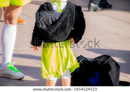 Young girl and parent wearing a colorful costume at a street carnival party