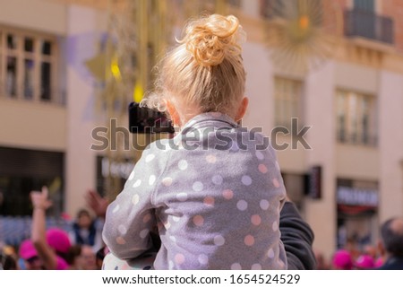 Young girl on her fathers shoulder at a street carnival party