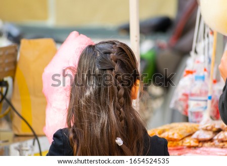 Young girl at a carnival street party with candy shop background