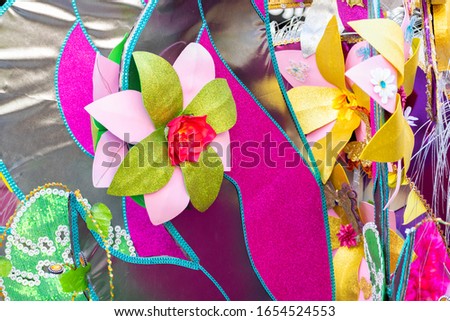 Detail of colorful samba dancers in costumes with sequins and glitter at a daytime Carnival street party.