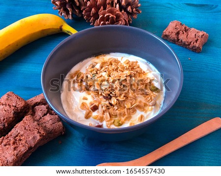Vegan breakfast of granola with Greek yogurt nuts and seeds very nutritious and healthy on dark blue background