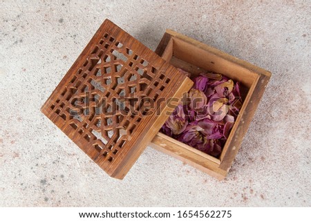 Vintage wooden aroma box with dried rose flowers on concrete background. Copy space for text.