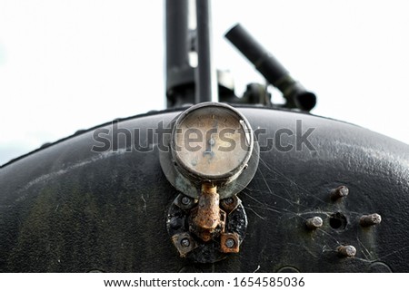 Close-up of a vintage steam pressure gauge located on the boiler of a very old steam traction engine.