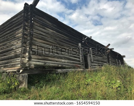 view of the old log house on a cloudy summer day