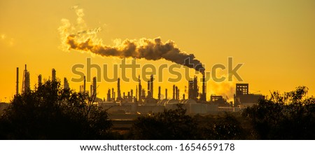 smoke stacks emmitting carbon pollution into the sky causing climate change  Royalty-Free Stock Photo #1654659178