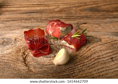 Sandwich with prosciutto, blue cheese and rosemary on wooden background.