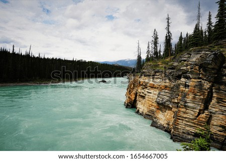 green blue water and yellow stone wall