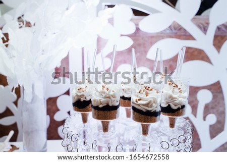 Delicious sweets on candy buffet. Lot of colorful desserts on table. Wedding party. Stylish luxury decorated candy bar for the celebration of a wedding of happy couple, cathering in the restaurant.