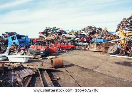 Crushed cars stacked up for recycling.  Royalty-Free Stock Photo #1654672786