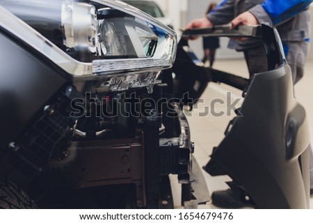 auto mechanic repair car body bumper replacement. Royalty-Free Stock Photo #1654679476