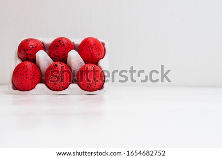 Easter set with red and  black ornated eggs in carton isolated on white background with copy space.