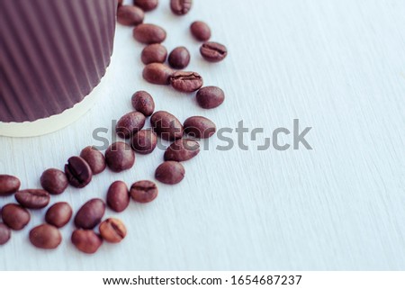 takeaway coffee in a red paper cup and with coffee grains