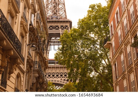 The Eiffel tower between buildings in the last rays of the sun. In yellow. Paris.France.