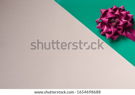 Decorative Flower woven from a ribbon. Composition on a textured background. Free space for text. Top view at an angle. Selective focus. Multitask background.