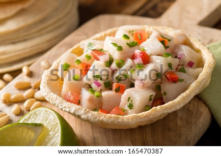 A freshly made white fish ceviche with tomato, red onion, cilantro, red pepper, lime, and serrano pepper. Royalty-Free Stock Photo #165470387