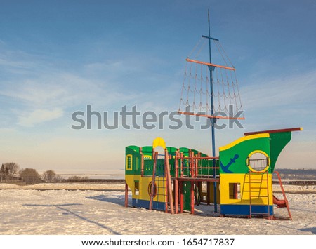 Children's game complex in  form of  wooden ship on  playground in winter city