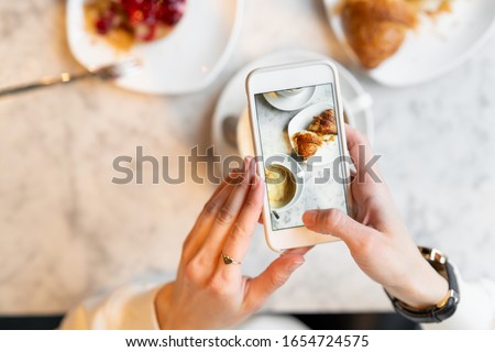 Taking food photo of breakfast with cellphone. using mobile phone for food photography