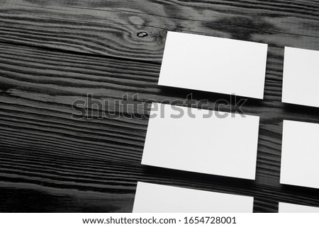 Business card blank on black wooden background. Corporate Stationery, Branding Mock-up. Creative designer desk. Flat lay. Copy space for text