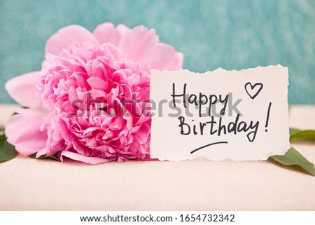 Happy birthday card with greeting words and bouquet of pink peony flowers