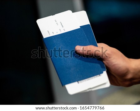 blue passport with a ticket in a man's hand. Stock photo. bright color in an airport