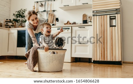 Happy family mother housewife and child son in laundry with washing machine 
 Royalty-Free Stock Photo #1654806628