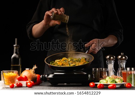 Cooking dishes with meat and vegetables. Oriental cuisine, Asia food. Seasoning, freezing in motion. Vegetables and meat, tasty and wholesome food. Royalty-Free Stock Photo #1654812229