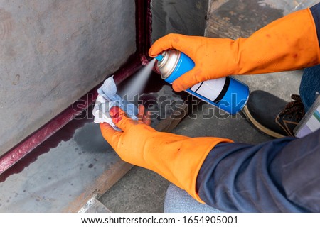 Step to use solvent remover spray into the rag to cleaning the welded surface before performing spray Liquid Penetrant for Non-Destructive Testing(NDT) with process Penetrant Testing(PT). Royalty-Free Stock Photo #1654905001