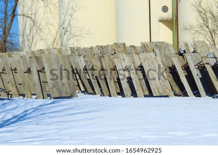 wooden picnic tables stacked away for winter.