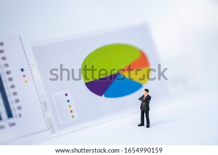 Miniature People: Business man looking at analyst graph with copy space using as background money, financial, business concept.