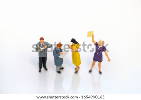 Miniature people: Business team reading news paper with copy space using as background business, education concept.