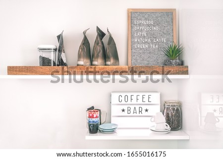 Coffee shop menu sign on wall shelves hipster trendy store for espresso shots. Felt letter board lightbox showing text selling cappuccino, latte, matcha tea.