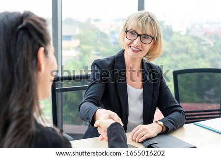 Businesswoman shaking hands with smile while meeting and she get a great deal.