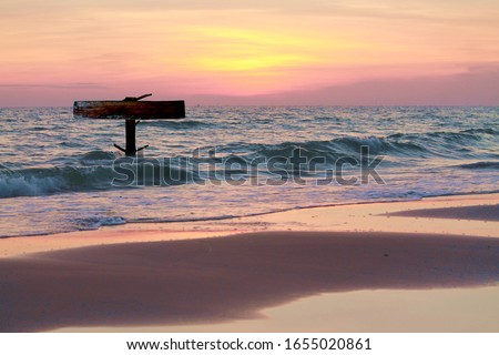 wooden rustic blank sign on the beach with sunset seascape background