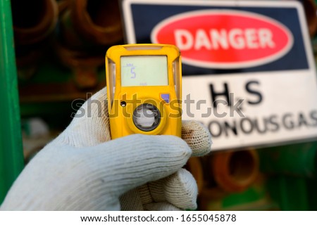 Oilfield technician checking H2S gas with his pocket type H2S Gas detector  in gas plant.  Royalty-Free Stock Photo #1655045878